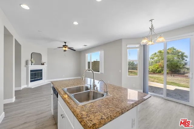 a kitchen that has a sink a microwave oven and a dining table with wooden floor
