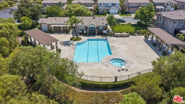 an aerial view of a house with outdoor swimming pool and tennis court