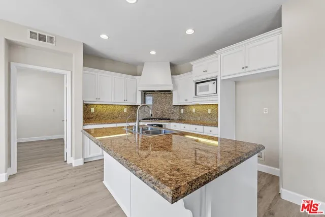 a large kitchen with kitchen island a sink stainless steel appliances and cabinets