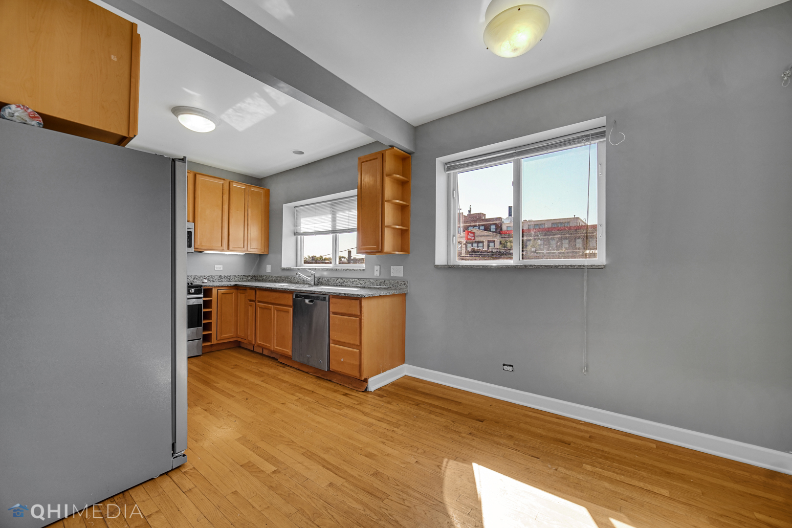 820 Dobson Street, Unit 2E Evanston, IL 60202 - Photo 17 of 19 a kitchen with stainless steel appliances granite countertop a stove a sink and a window
