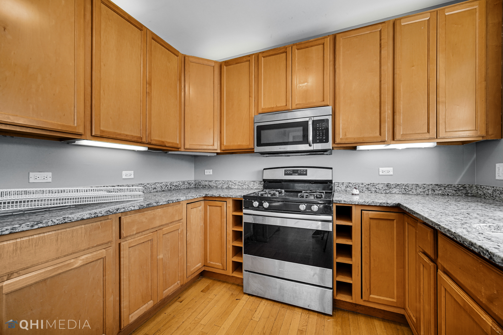 820 Dobson Street, Unit 2E Evanston, IL 60202 - Photo 10 of 19 a kitchen with granite countertop wooden cabinets and a stove top oven