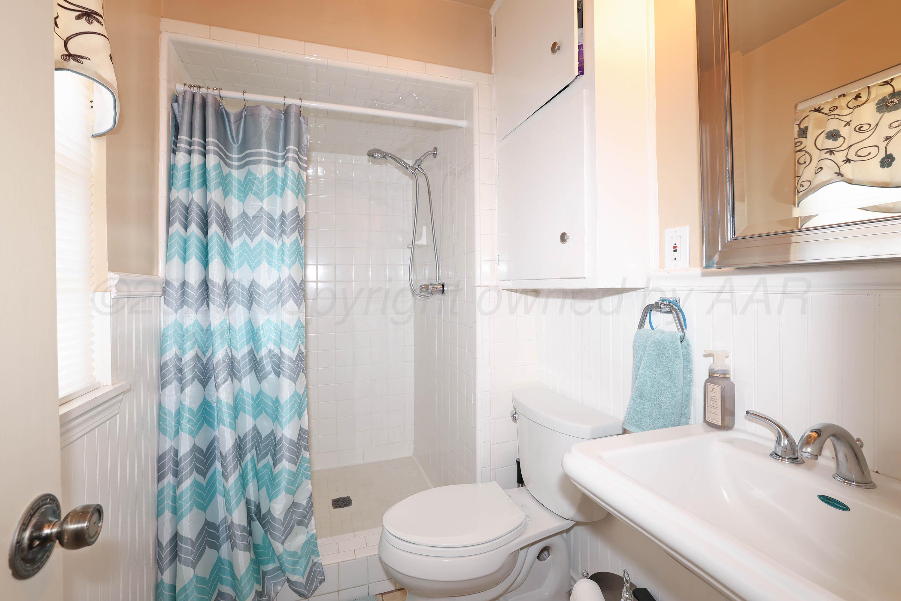 4119 Tucson Drive Amarillo, TX 79109 - Photo 12 of 22 a bathroom with a sink toilet and shower