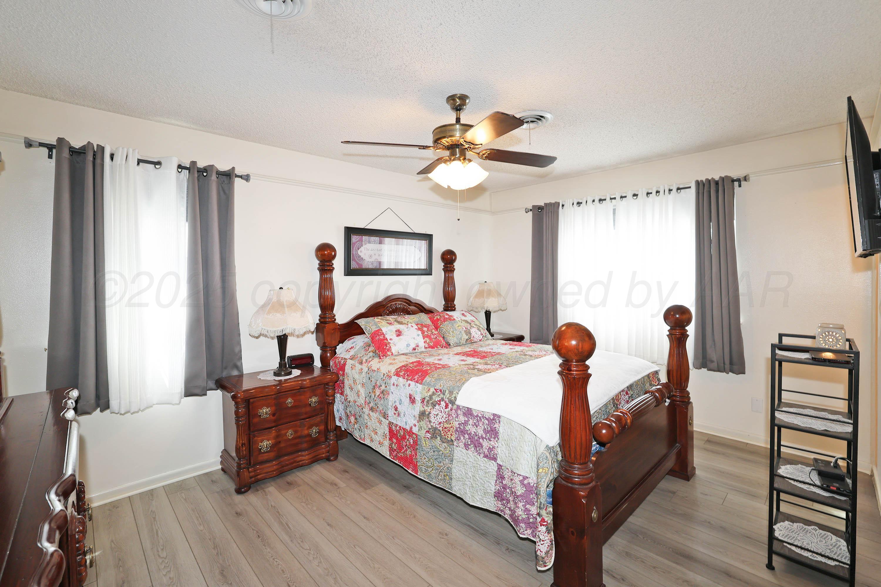 4119 Tucson Drive Amarillo, TX 79109 - Photo 10 of 22 a bedroom with a bed and a chandelier