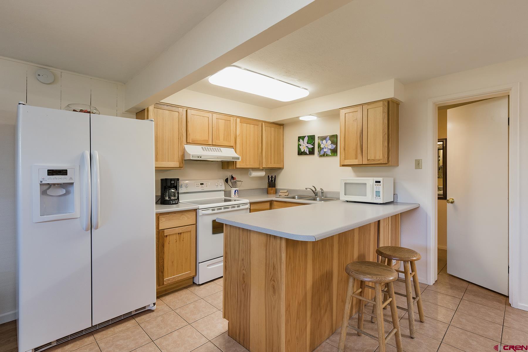 400 Sheol Street, Unit 8 Durango, CO 81301 - Photo 10 of 35 a kitchen with a sink a refrigerator a stove and white cabinets