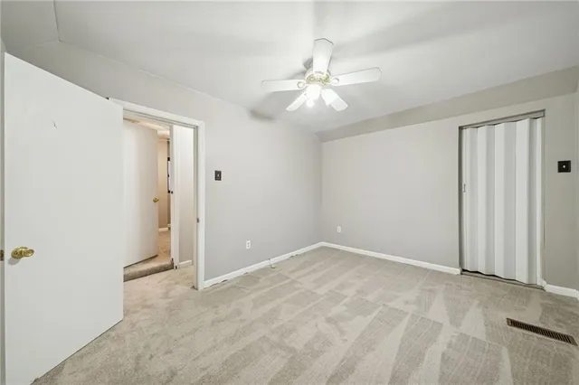 a view of an empty room with a chandelier fan