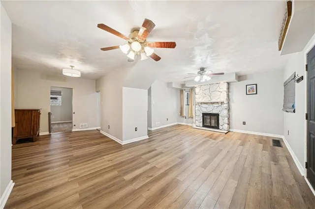 a view of empty room with wooden floor and fireplace