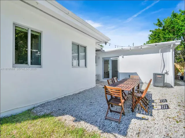 a backyard of a house with table and chairs