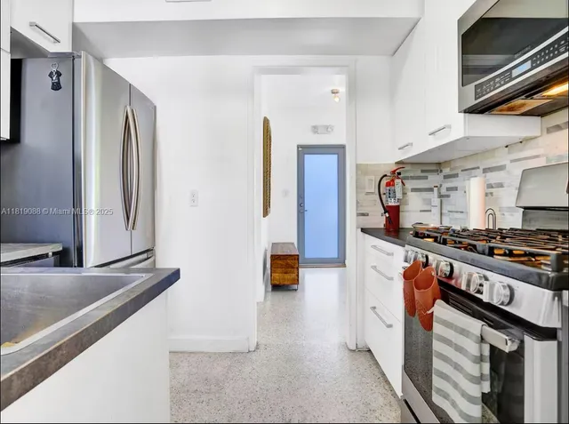 a kitchen with stainless steel appliances granite countertop a stove and a refrigerator