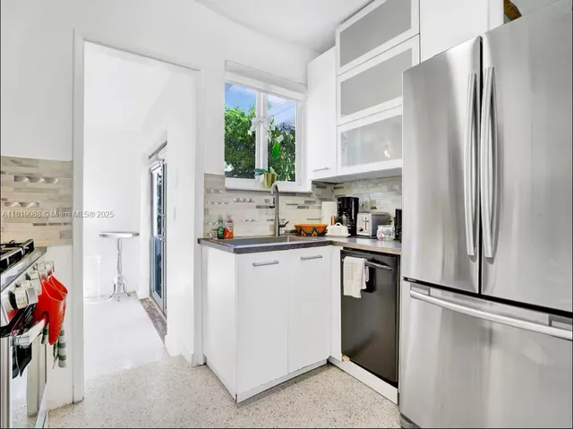 a kitchen with stainless steel appliances a refrigerator sink and cabinets