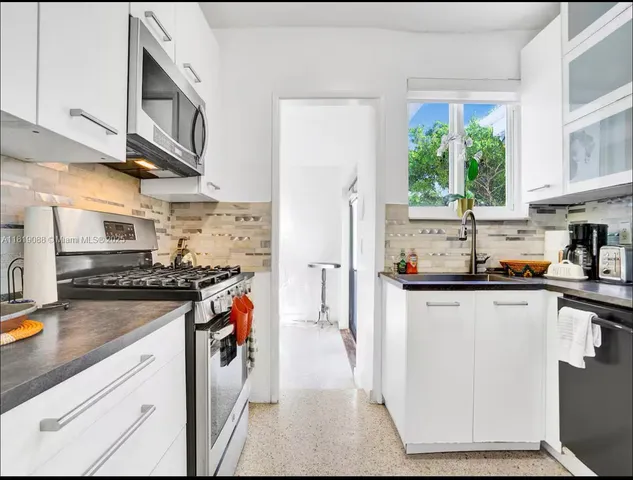 a kitchen with stainless steel appliances granite countertop a stove and a sink