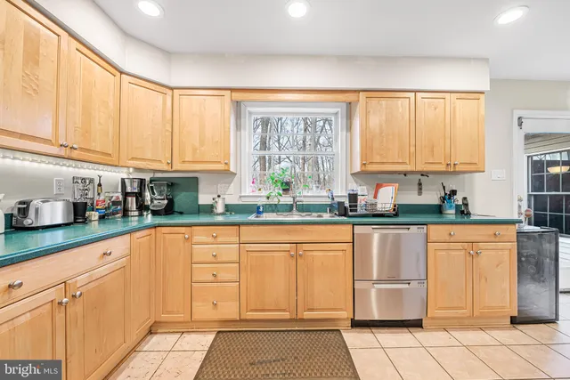 a kitchen with stainless steel appliances granite countertop a stove a sink and white cabinets