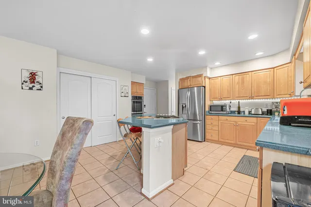 a kitchen with stainless steel appliances granite countertop a stove a sink a refrigerator and a microwave