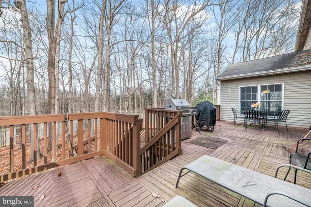 a view of a house with wooden deck and furniture