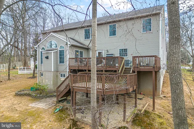 a view of a patio with table and chairs with wooden floor and fence