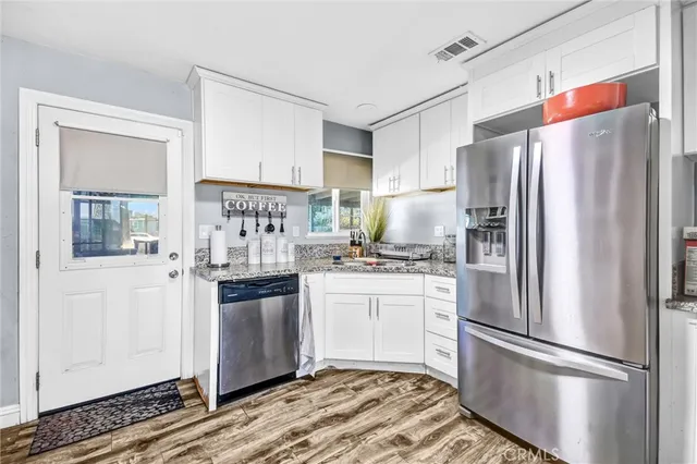 a kitchen with stainless steel appliances a refrigerator sink and cabinets