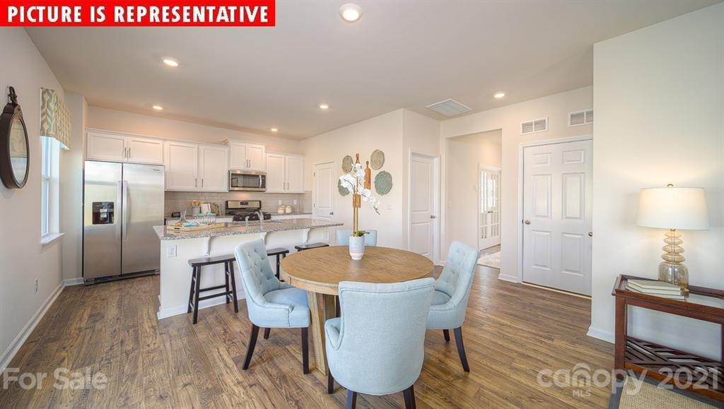 106 Sierra Road Mooresville, NC 28117 - Photo 10 of 32 a kitchen with a dining table chairs and refrigerator