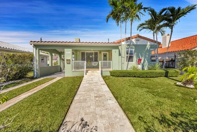 a front view of a house with a garden and yard