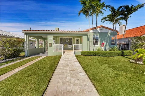a front view of a house with a garden and yard