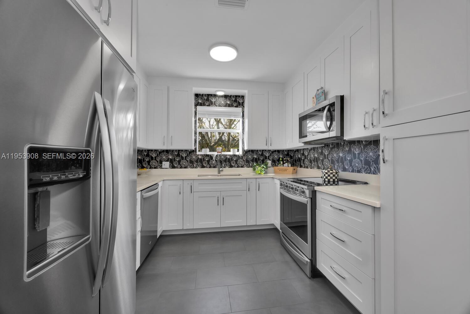 2431 Southwest 22nd Terrace Miami, FL 33145 - Photo 6 of 22 a kitchen with white cabinets and refrigerator
