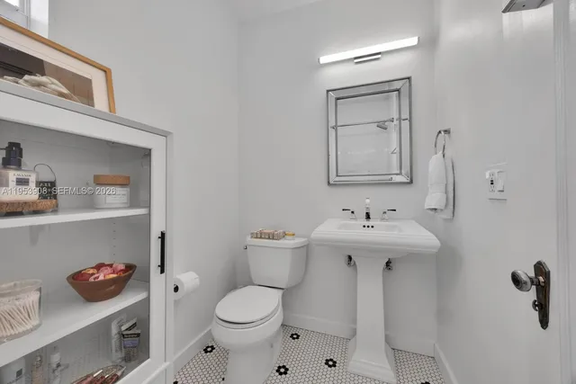 a bathroom with a sink a toilet and a mirror