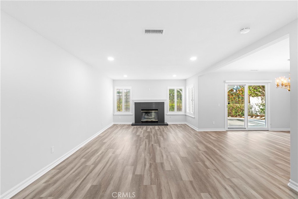 26433 Emerald Dove Drive Valencia, CA 91355 - Photo 2 of 50 an empty room with wooden floor fireplace and windows