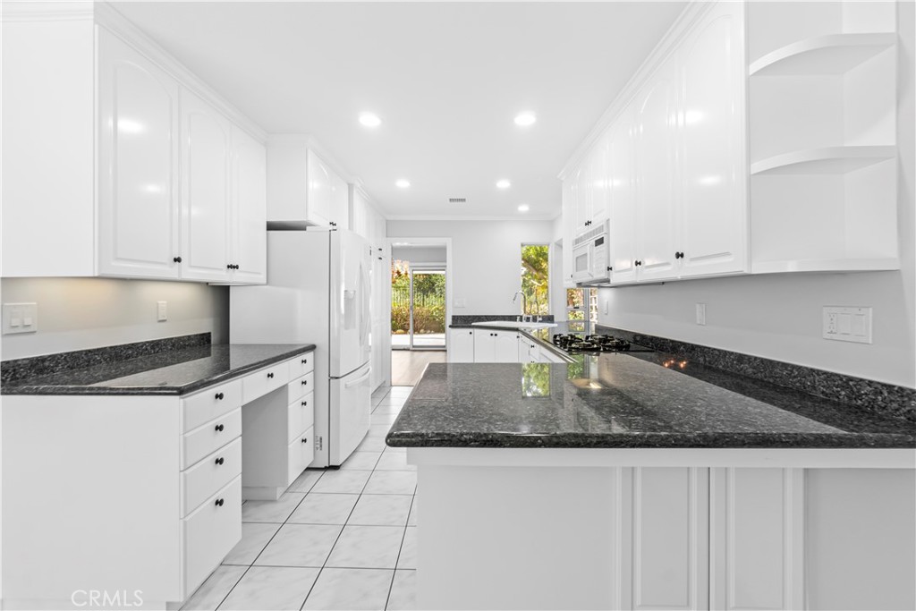 26433 Emerald Dove Drive Valencia, CA 91355 - Photo 7 of 50 a kitchen with granite countertop white cabinets white stainless steel appliances and a sink