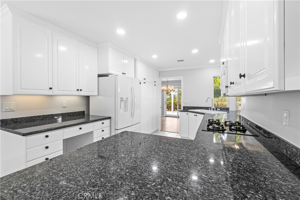 26433 Emerald Dove Drive Valencia, CA 91355 - Photo 8 of 50 a large white kitchen with stainless steel appliances granite countertop a stove a sink a refrigerator and white cabinets