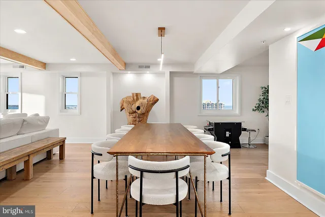 a bedroom with a bed a potted plant on dresser and a wooden floor