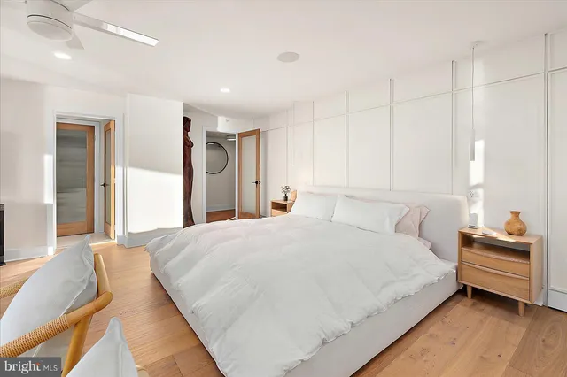 a large bedroom with a large bed a chandelier and windows