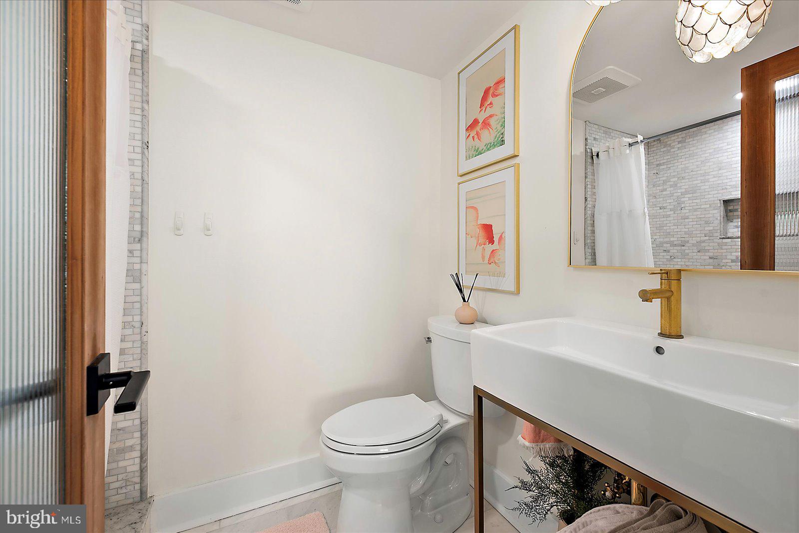 11000 Coastal Highway, Unit 2000 Ocean City, MD 21842 - Photo 61 of 102 a bathroom with a sink and a toilet