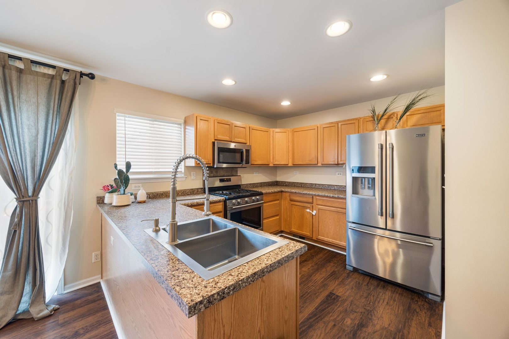 893 Emerald Drive Pingree Grove, IL 60140 - Photo 6 of 18 a kitchen with kitchen island a counter top space a sink stainless steel appliances and cabinets