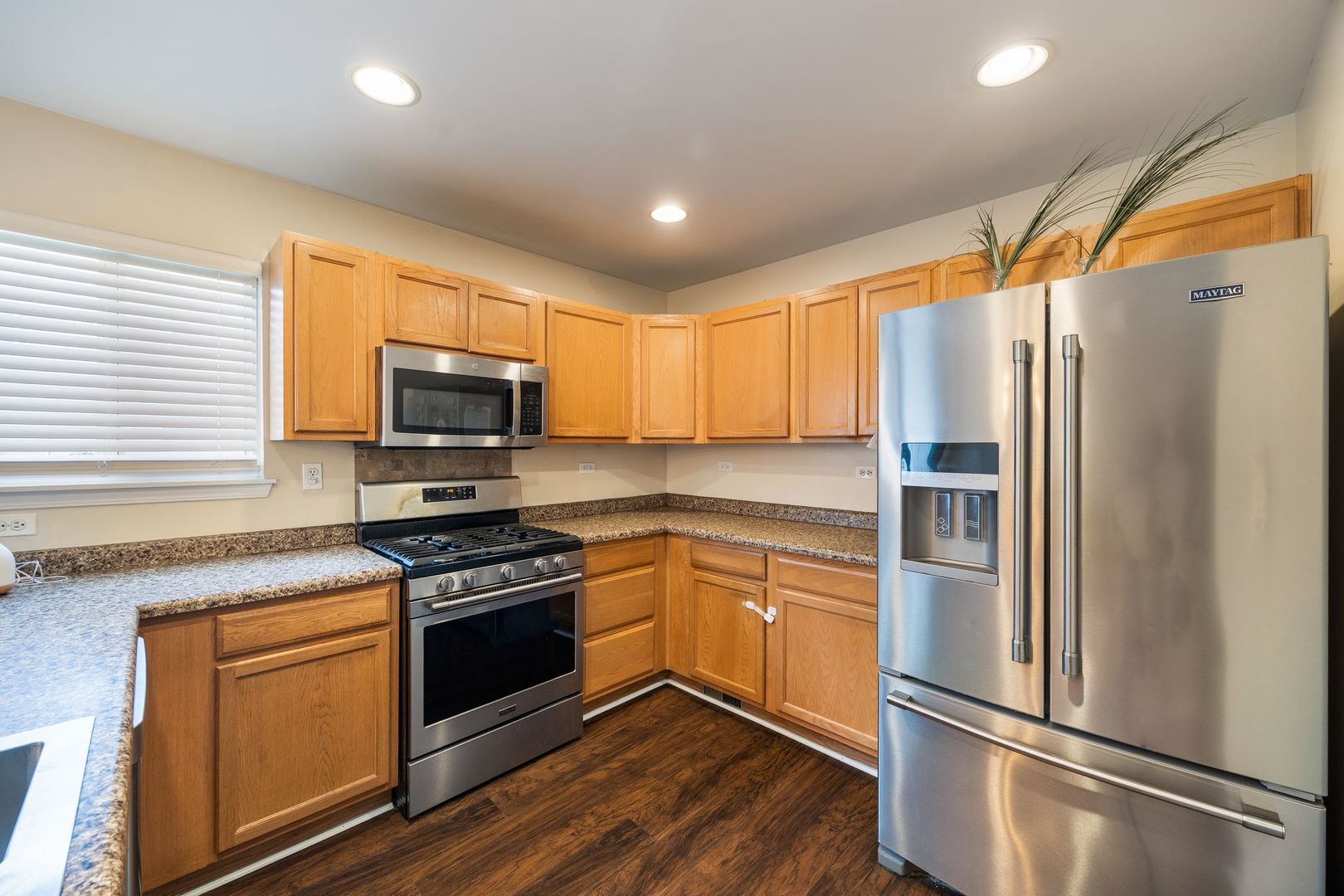 893 Emerald Drive Pingree Grove, IL 60140 - Photo 7 of 18 a kitchen with stainless steel appliances granite countertop a refrigerator a stove top oven a sink and dishwasher