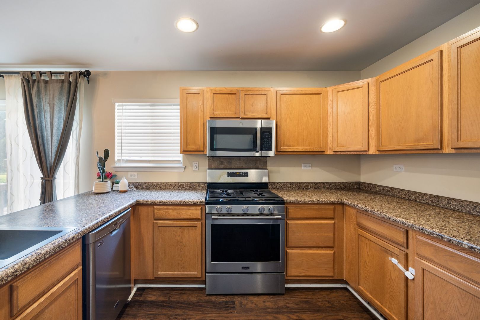 893 Emerald Drive Pingree Grove, IL 60140 - Photo 8 of 18 a kitchen with granite countertop a stove sink and microwave