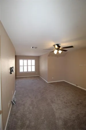 an empty room with windows and fan