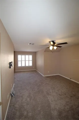 an empty room with windows and fan