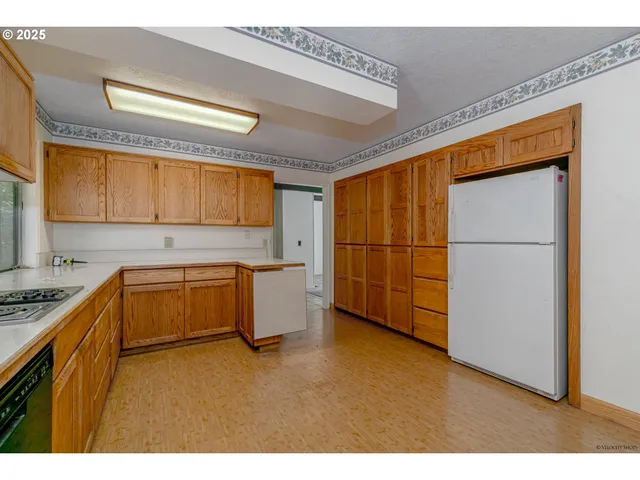 a kitchen with stainless steel appliances granite countertop a sink a stove a refrigerator a counter top space and cabinets