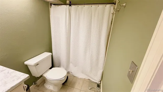 a white toilet sitting next to a shower curtain