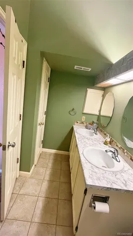 a bathroom with a granite countertop sink a mirror and a shower