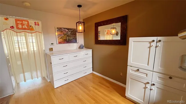 a view of a bedroom with wooden floor and cabinet