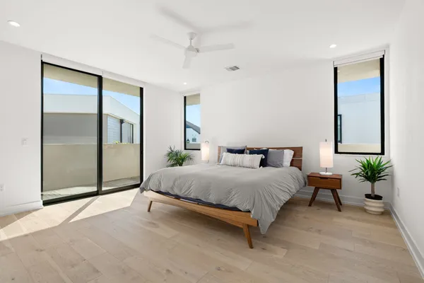 a spacious bedroom with a bed and a potted plant