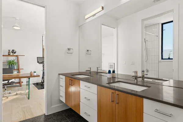 a bathroom with double sink and a mirror