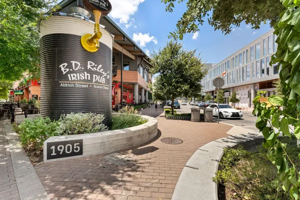a view of a street with benches and buildings