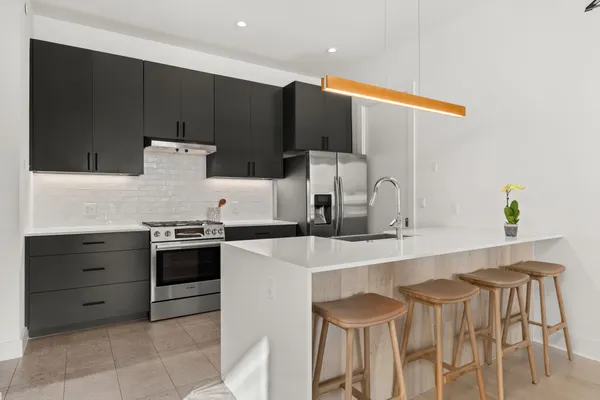 a kitchen with stainless steel appliances a sink and a refrigerator