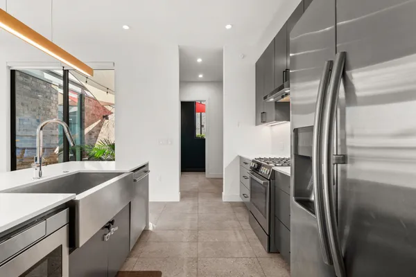 a kitchen with stainless steel appliances granite countertop a refrigerator and a sink