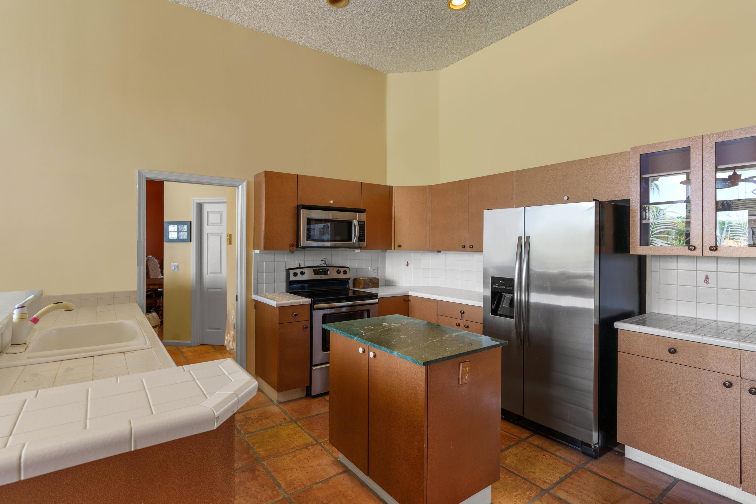 2687 Northwest 39th Street Boca Raton, FL 33434 - Photo 11 of 34 a kitchen with stainless steel appliances granite countertop a refrigerator a stove top oven a sink and dishwasher