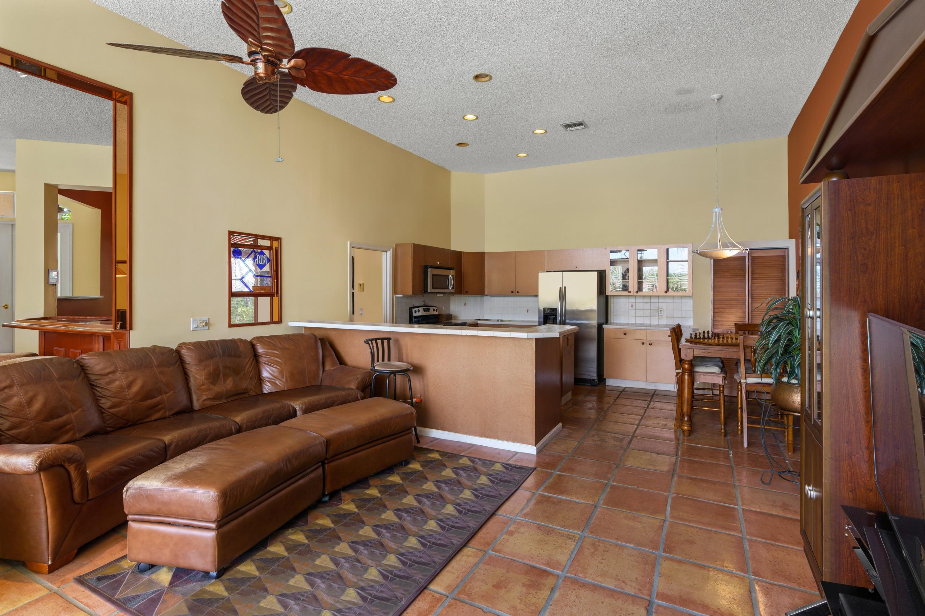 2687 Northwest 39th Street Boca Raton, FL 33434 - Photo 10 of 34 a living room with furniture a rug and kitchen view