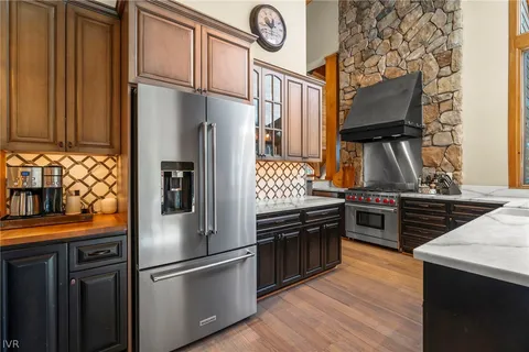 a kitchen with stainless steel appliances granite countertop a refrigerator and a stove