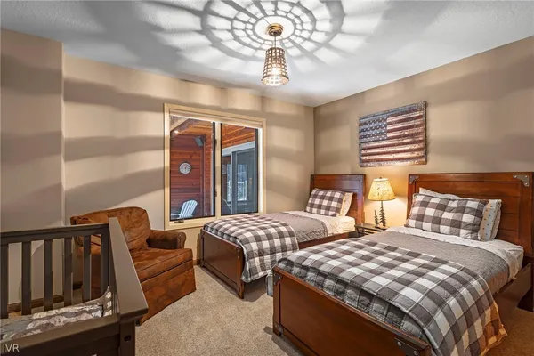 a bedroom with two beds and a chandelier