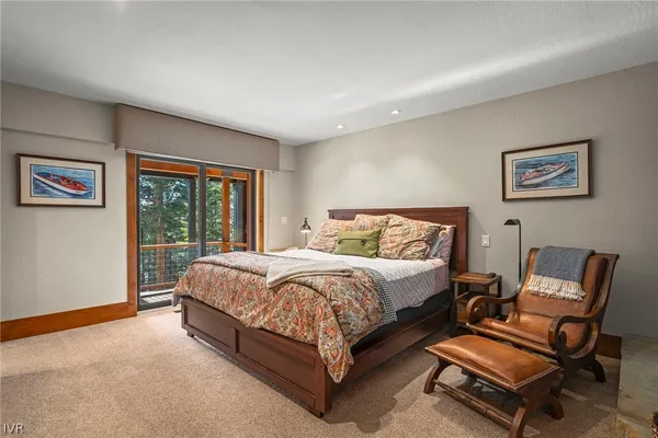 a bed sitting in a spacious bedroom next to a window
