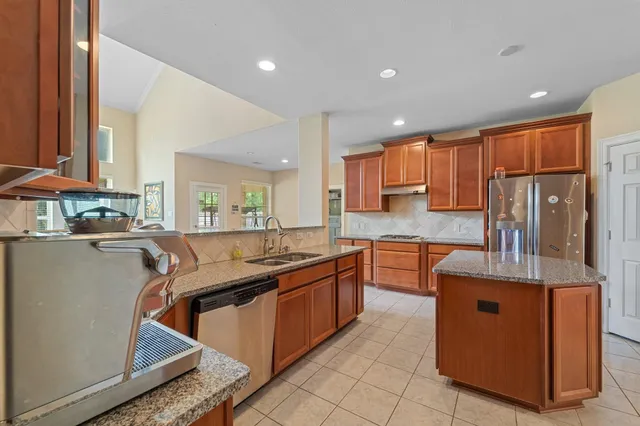 a kitchen with stainless steel appliances granite countertop a sink stove and refrigerator
